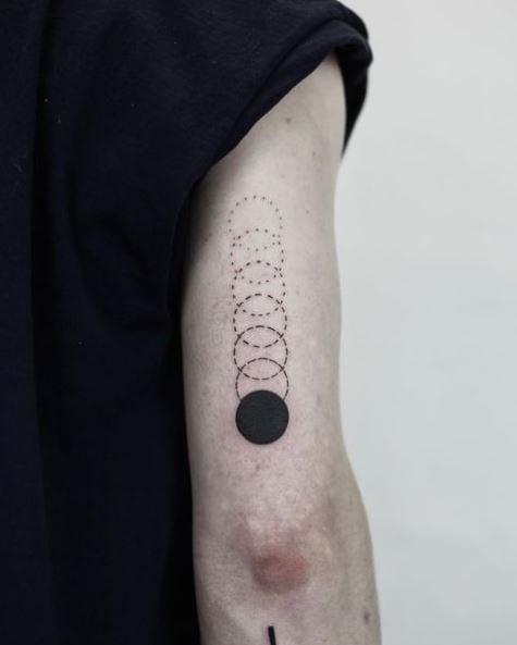 Black Circle Gravity Back of Arm Tattoo