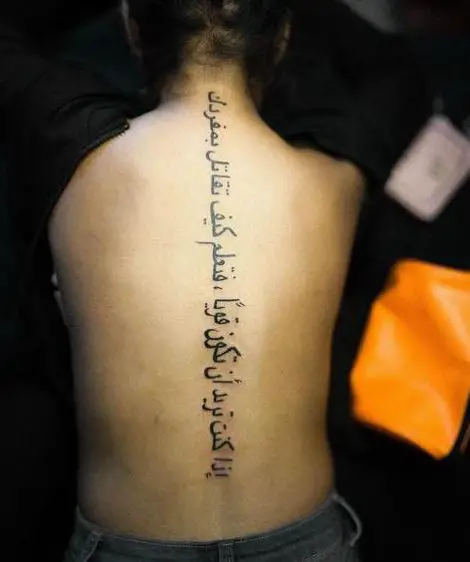 Long Arabic Phrase Back Tattoo