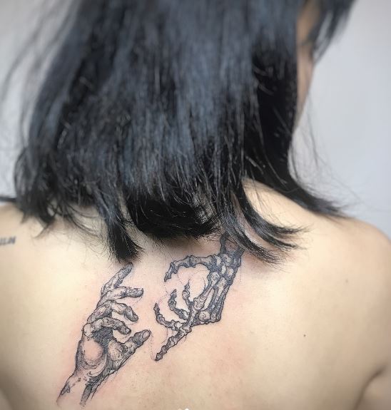Grey Skeletal Hand and Human Hand Back Tattoo