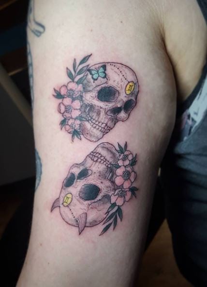 Pair of Skulls with Flowers Biceps Tattoo
