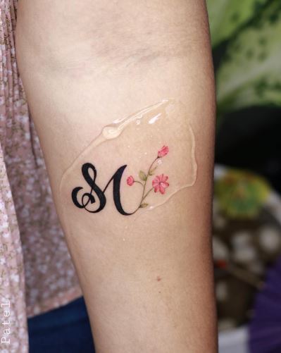 Calligraphic Initial Letters SM with Flowers Forearm Tattoo