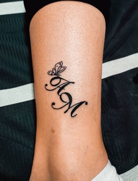 Calligraphic Initial Letters AM with Butterfly Leg Tattoo