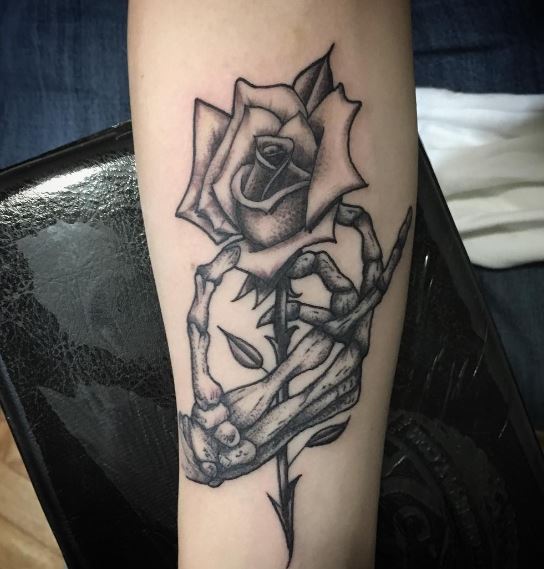 Black and Grey Skeleton Hand with Rose Biceps Tattoo