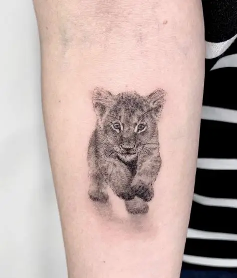 Minimalistic Running Lion Cub Forearm Tattoo