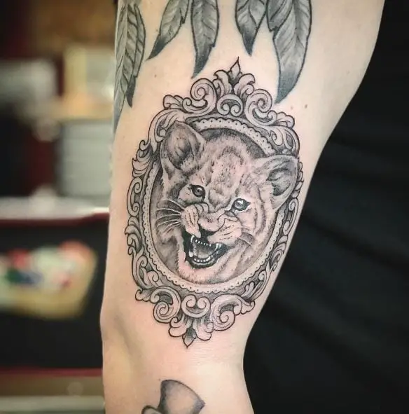 Black and Grey Framed Lion Cub Arm Tattoo