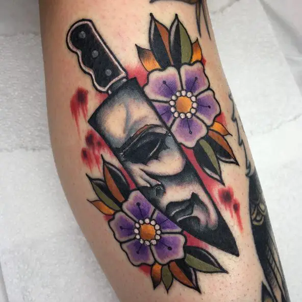 Colorful Flowers, and Knife with Michael Myers Face on Blade Forearm Tattoo