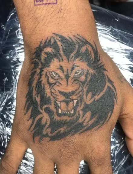 Black and Grey Tribal Lion Hand Tattoo