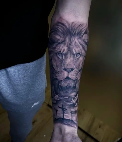 Black and Grey Three Crosses and Lion Forearm Tattoo