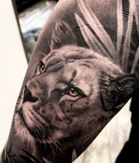 Black and Grey Leaves and Lioness Arm Sleeve Tattoo