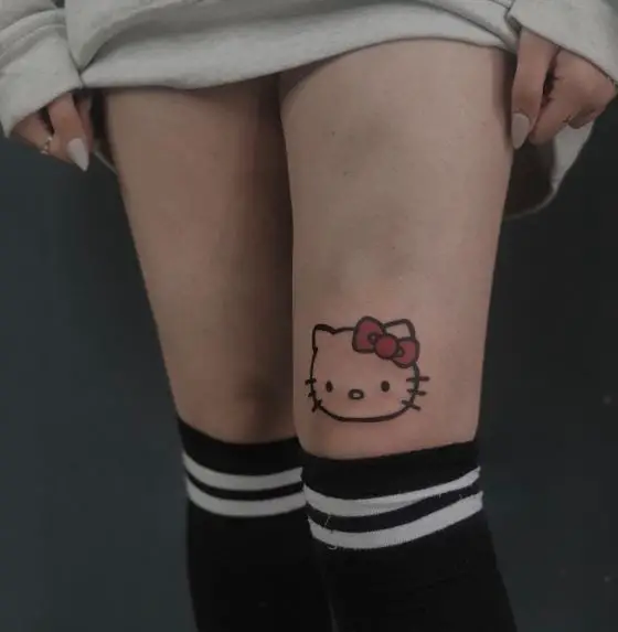 Hello Kitty Head with Red Bow Above Knee Tattoo