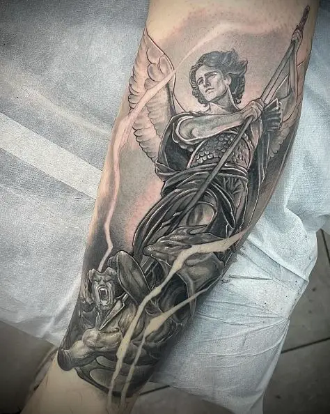Black and Grey Saint Michael with Spear Defeating Satan Forearm Tattoo