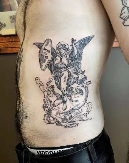 Black and Grey Saint Michael with Sword and Shield Killing Dragon Ribs Tattoo