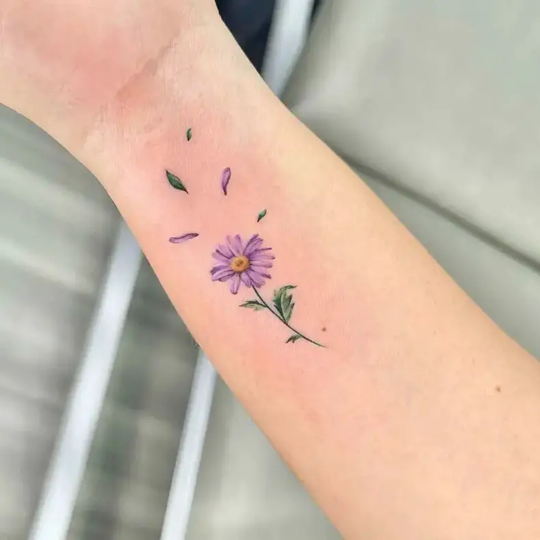 Flying Petals and Leaves of Purple Daisy Flower Tattoo Design