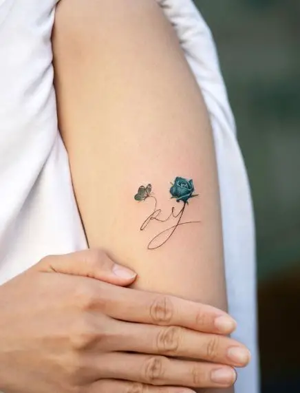 R and Y Initials with a Blue Rose and Butterfly Tattoo