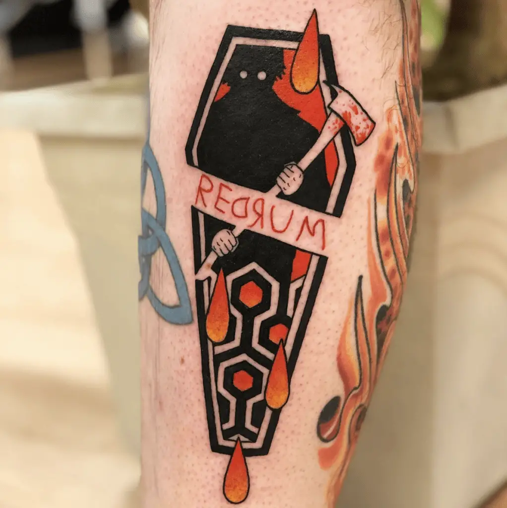 A Colored Man Holding an Axe in a Coffin with Blood Drops Leg Tattoo