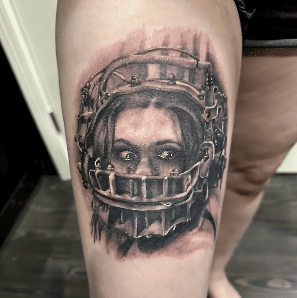 A Soft Detail of a Woman With an Iron Mask Thigh Tattoo