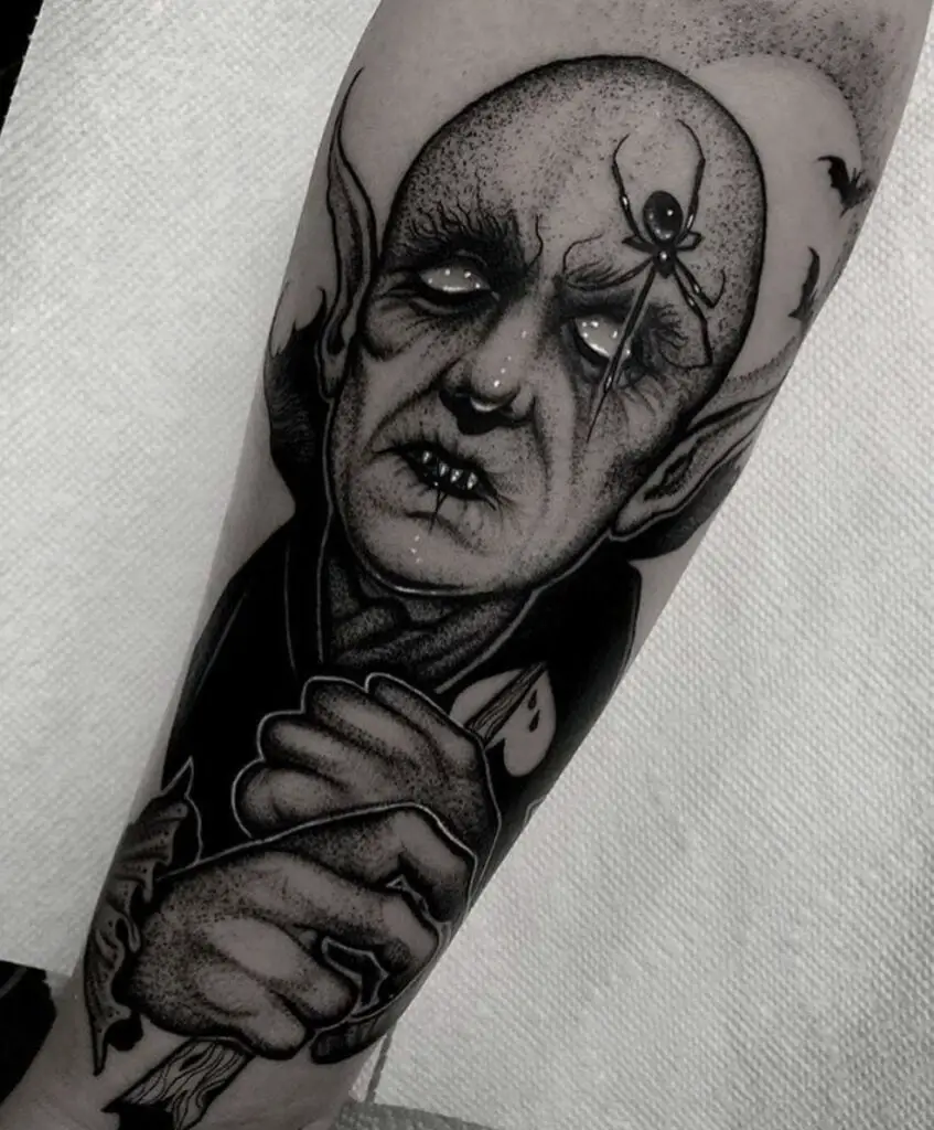 Bald Vampire Blind Man WIth Spider on His Forehead Arm Tattoo