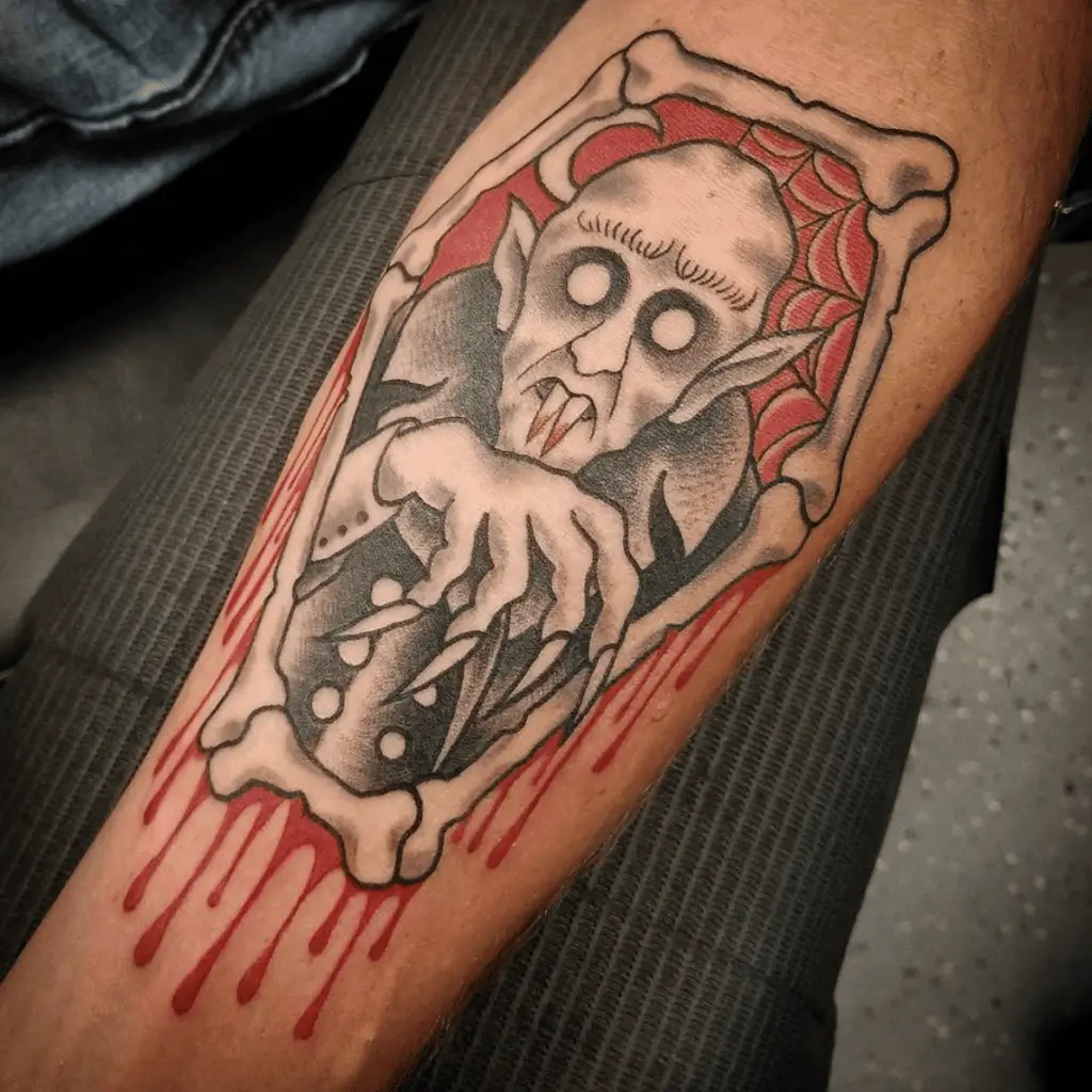 Bald Vampire in a Bone Frame Coffin With Red Blood Dripping Arm Tattoo