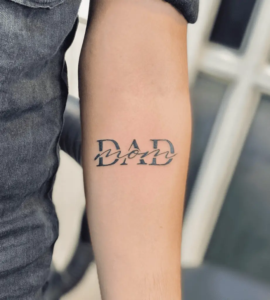 Black Ink Blended Mom and Dad Lettering Arm Tattoo