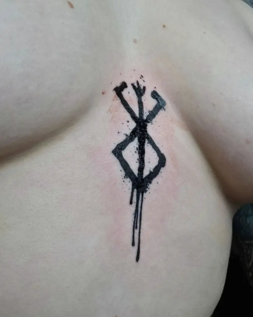 Black Ink Drop Berserk Logo Between Boob Tattoo