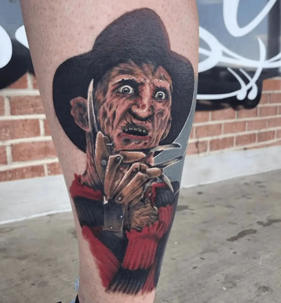 Colored Burned Face of a Man Wearing a Hat, Sweater and Claw Gloves Leg Tattoo