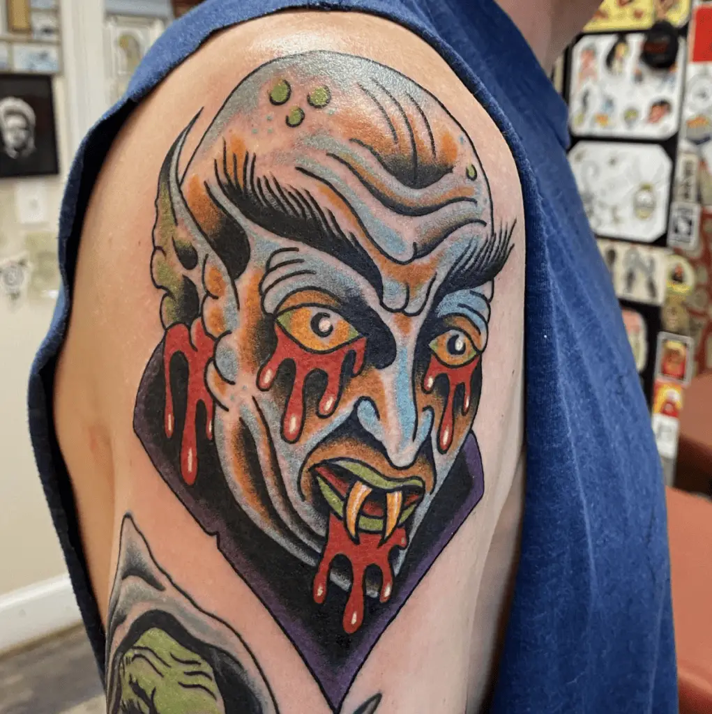 Colored Illustration Bloody Bald Vampire Upper Arm Tattoo
