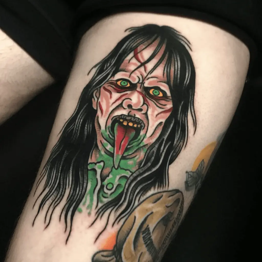 Colored Long Hair Wrinkled Woman Sticking Out Her Tounge With Vomit All Over Her Mouth Thigh Tattoo