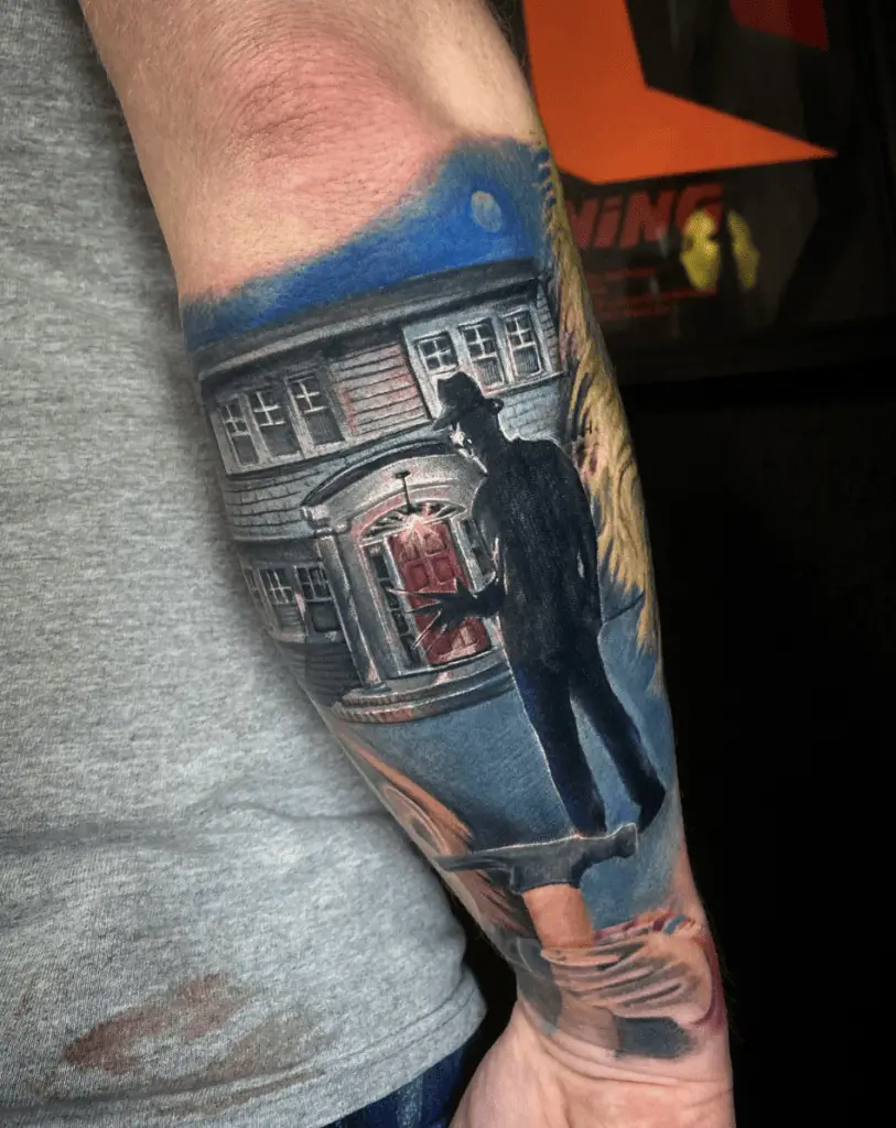 Colored Man in Silhouette Wearing a Hat Standing in Front of a House Forearm Tattoo