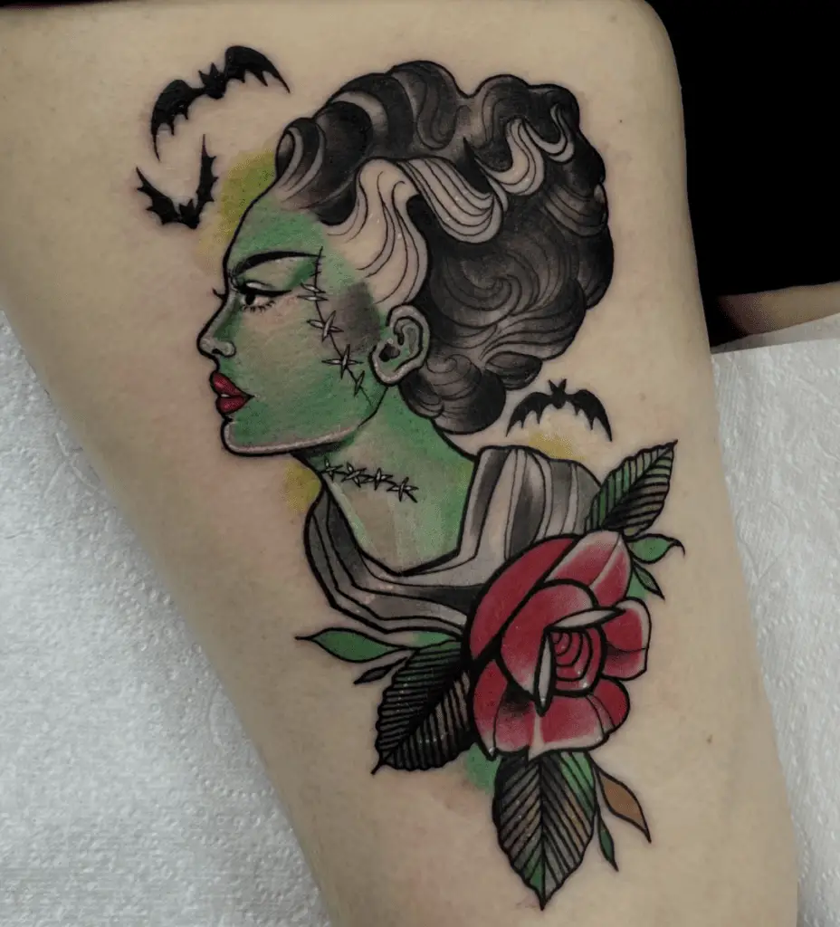 Colored Side Profile of a Woman With Bats and Flower Arm Tattoo