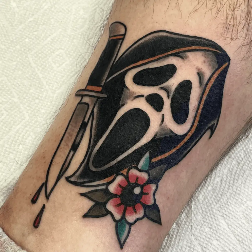 Grim Reaper Screaming With A Knife With Drops Of Blood And Flower Leg Tattoo