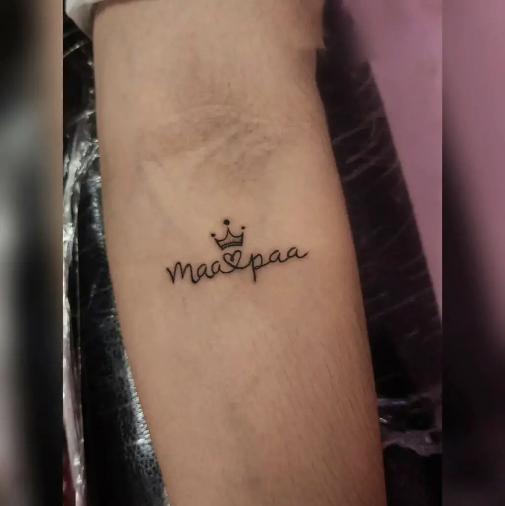 Mom and Dad in Calligraphy Text With Tiny Heart and Crown Arm Tattoo