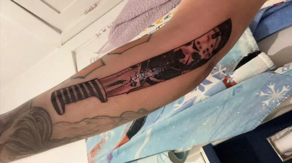 Refelction of a Masked Man in Machete Forearm Tattoo