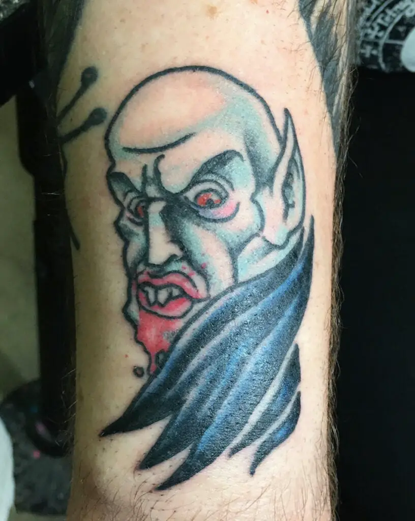 Side View Bald Vampire With Blood on His Mouth Arm Tattoo