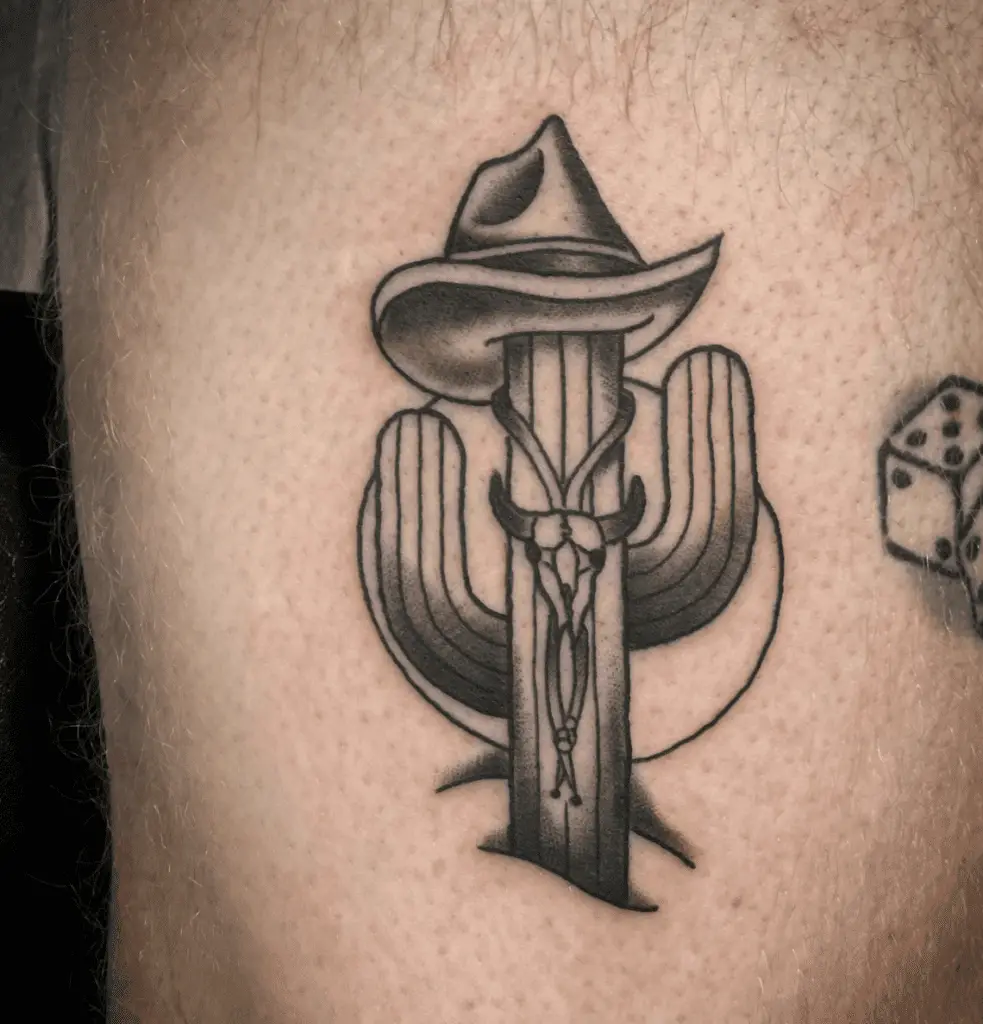 A Little Cactus With a Bolo Tie and Cowboy Hat Thigh Tattoo