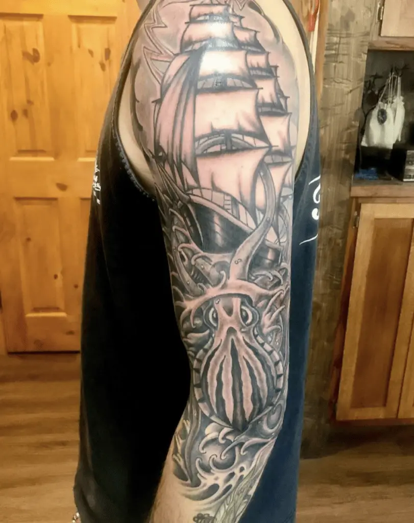 Black and Grey Illustration Kraken Crawling Under the Battle Ship Upper Arm Tattoo