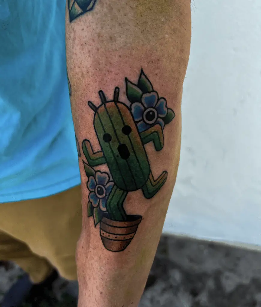 Colored Cactus Face in Dashing Pose With Flowers Arm Tattoo