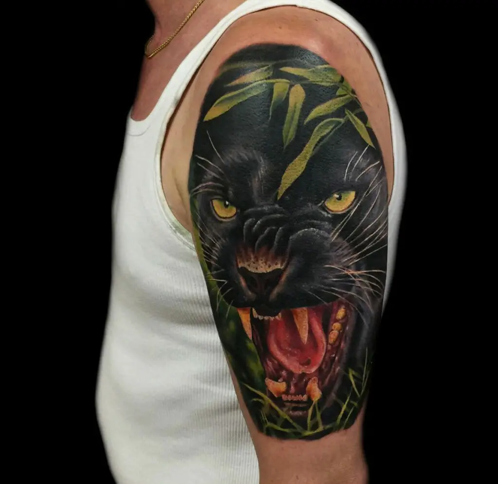 Colored Graphic of Close Up Black Panther in Leaves Upper Arm Tattoo