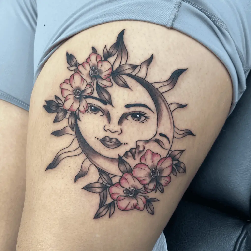 Sun and Moon With Feminine Face Surrounded By Flowers Thigh Tattoo