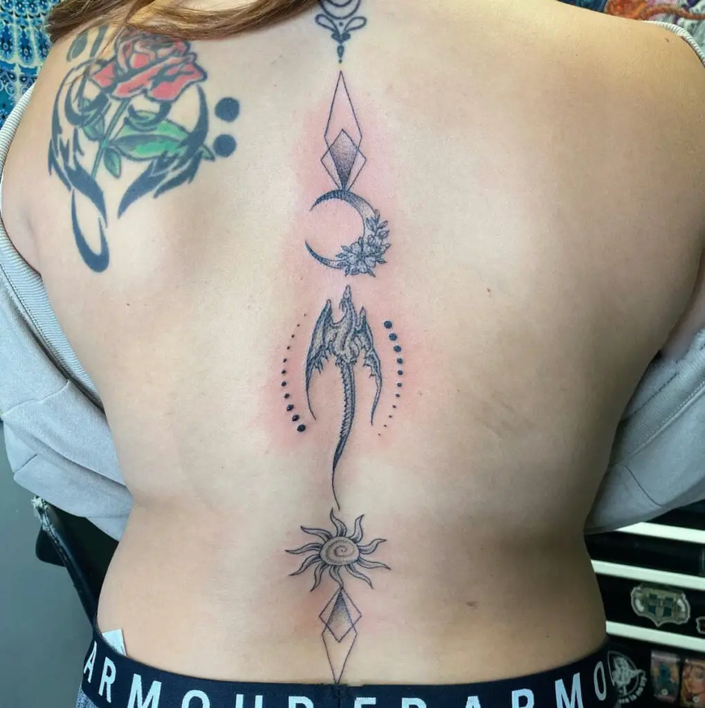 Sun and Moon and a Dragon in Between Spine Tattoo