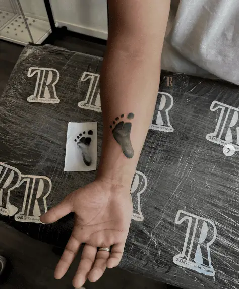 Black Ink Baby Footprint Forearm Tattoo