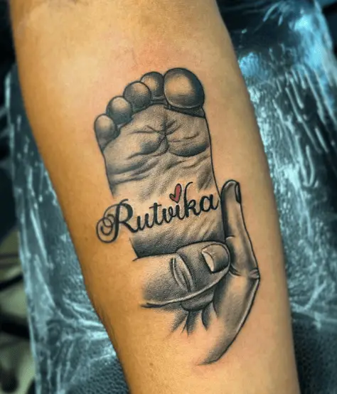 Mother Holding Baby's Foot with Name Tattoo 