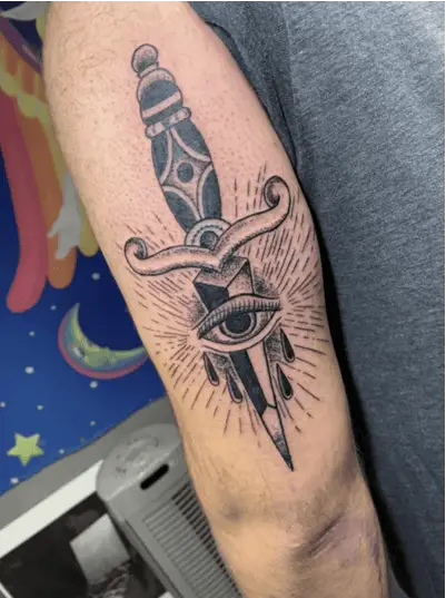 Black and Grey Traditional Eye With Dagger and Rays Upper Arm Tattoo