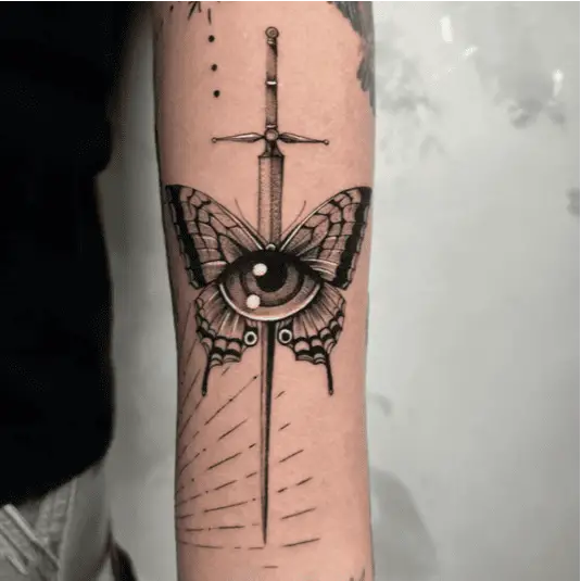 Black and Grey Human Eye With Butterfly and Long Sword Arm Tattoo