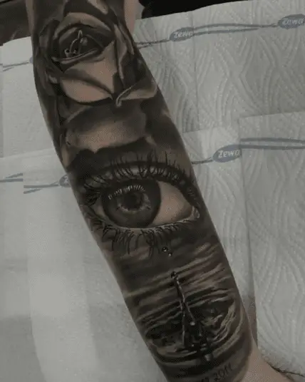 Black and Grey Realistic Eye With Tear Drop of Water and Rose Arm Tattoo Roses