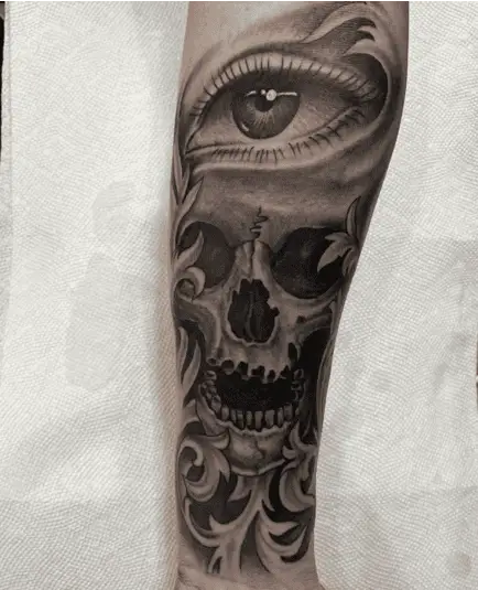 Black and Grey Eye in Skull With Leaves Leg Tattoo