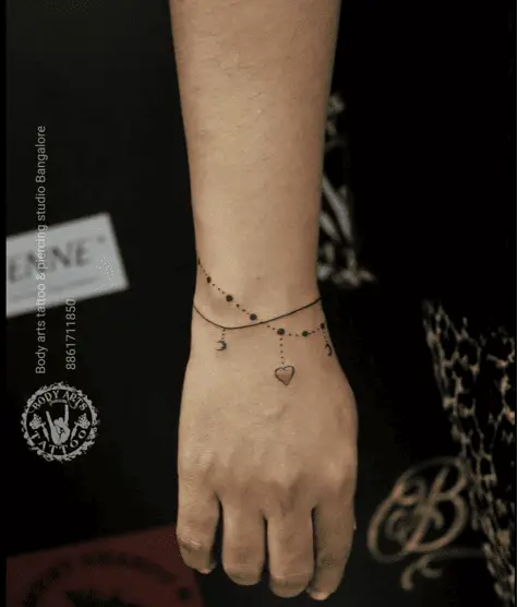 A Red Heart and Moon Charm Bracelet Wrist Tattoo