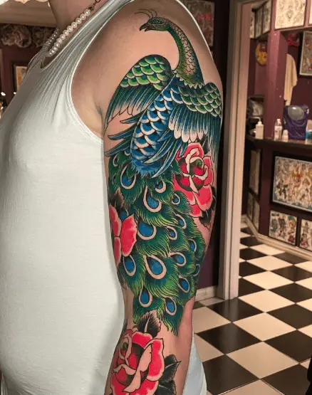 Green and Blue Peacock with Red Flowers Arm Tattoo