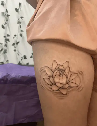 A Lotus Sitting on Soft Ripples of Water Thigh Tattoo