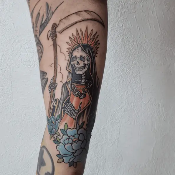 Santa Muerte Grim Reaper Chain on her Chest With Two Blue Flowers Tattoo